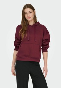 Dieprode hoodie met een voorzak, geribbelde boorden en zoom, met een ontspannen pasvorm en een zachte stoffen textuur.