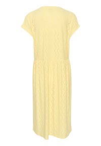 Vestido amarillo de longitud a la rodilla, hecho de un tejido texturizado con un patrón de ojetes y un sutil diseño ondulado. Mangas cortas y detalle de cintura elástica.