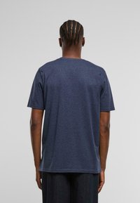 Námořnická modrá bavlněná tričko s krátkým rukávem, kulatým výstřihem a rovného střihu. Měkká textura a minimalistický design, bez viditelných log a vzorů.