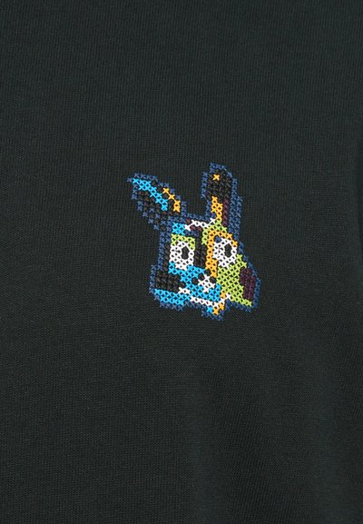 Față abstractă de câine realizată în stil broderie pe un fundal de țesătură de culoare verde închis, cu ochi și urechi mari, într-o paletă vibrantă de culori.