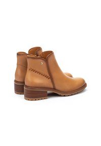 Bottines en cuir marron avec un bout arrondi, des coutures texturées sur le côté et un talon en bois empilé. Fini lisse, accents minimaux.