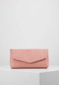 Soft pink suede clutch purse with a gold-trimmed triangular flap, resting on a white surface against a plain light background.