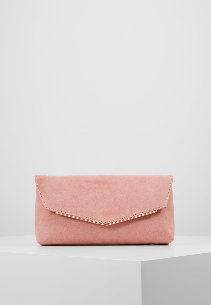 Soft pink suede clutch purse with a gold-trimmed triangular flap, resting on a white surface against a plain light background.