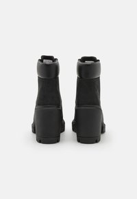 Black ankle boots with a combination of leather and suede. Rounded toe, sturdy block heel, and padded collar. Textured finish with minimal accents.