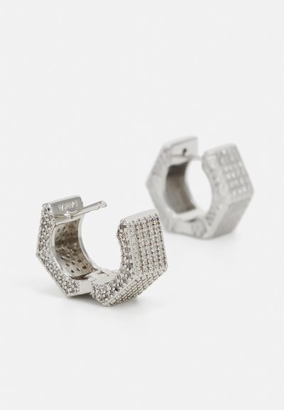 Silver hexagonal hoop earrings with textured surfaces, featuring small sparkling accents on one side and a smooth interior.