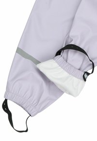 Pantalon de pluie violet avec poignets élastiqués et doublure intérieure blanche. Il est équipé d'une sangle plate noire pour un ajustement sécurisé et d'un accent réfléchissant gris.