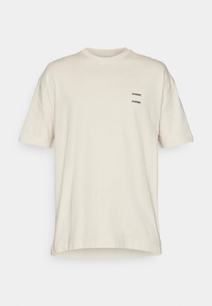T-shirt beige a maniche corte con scollo a girocollo e piccolo testo nero "SAMSOE" stampato due volte sul lato sinistro del petto.