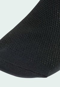 Primo piano di un tessuto a maglia nero con una sottile bordatura a coste, che mostra un'intrecciatura dettagliata e un leggero effetto lucido.