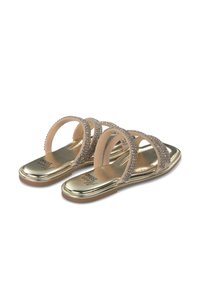 Gold sandals with a flat sole, featuring three transparent straps adorned with rhinestones. Soft, smooth texture. Casual design.