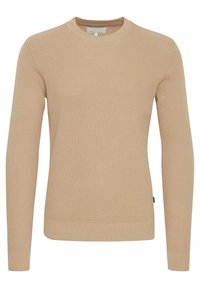 Beige gebreide trui met een ronde hals, lange mouwen en een gestructureerd patroon. Heeft ribgebreide manchetten en een zoom.