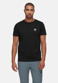 Zwarte katoenen T-shirt met een ronde hals, korte mouwen en een klein rond logo op de borst. Gladde textuur.