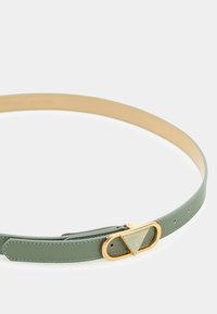 Zielony skórzany pasek z metalową klamrą w złotym odcieniu, z trójkątnym logo. Gładka faktura i minimalistyczny design, z wieloma dziurkami.