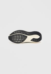 Semelle de chaussure en caoutchouc noir dotée d'un motif texturé avec des formes en diamant ; bordure blanche contrastante le long du périmètre ; section centrale lisse.