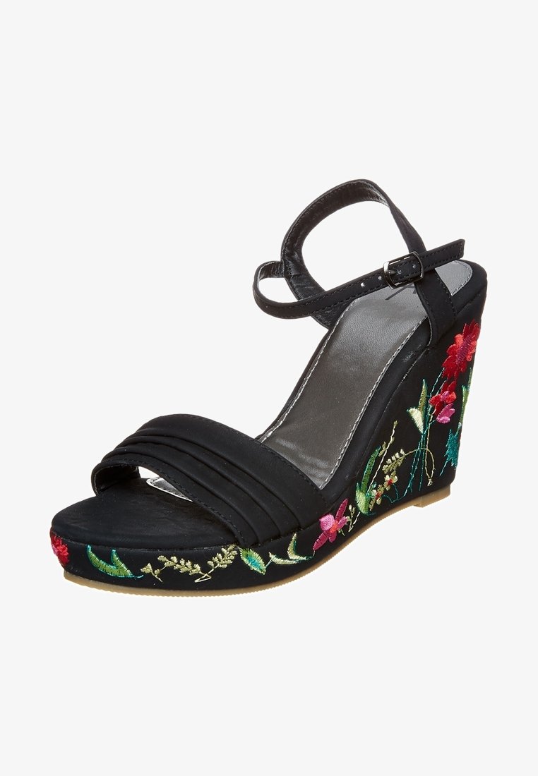 Sandale compensée noire avec bride à la cheville et boucle, ornée d’une broderie florale colorée le long de la semelle et du talon compensé.