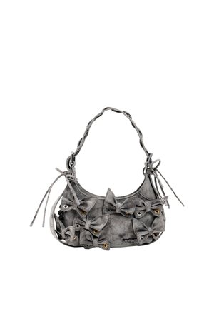 Bolso gris con un asa torcida, decorado con múltiples lazos de tela y ojales metálicos en la parte delantera, etiquetado como Desigual.