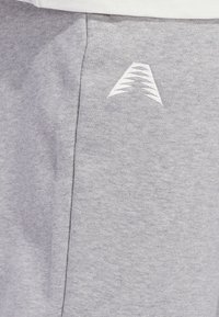 Γκρι βαμβακερές φόρμες με λευκό λογότυπο, υφή ματ και λεπτομέρεια στη ραφή στο πλάι. Κλασικός σχεδιασμός με άνετη εφαρμογή.