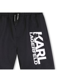 Μαύρο μαγιό βερμούδα με ελαστική μέση και κορδόνι. Διαθέτει έντονο λευκό λογότυπο με την επιγραφή "KARL LAGERFELD".