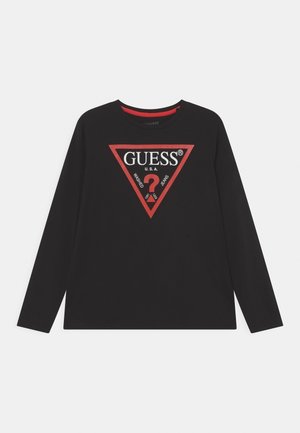 T-shirt noir à manches longues en coton avec un grand logo triangulaire rouge au centre portant le texte "GUESS U.S.A.".