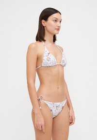 Bikini set met een bloemenpatroon in pasteltinten, met een driehoekige top en verstelbare zijstrik-broekjes, gemaakt van gladde stof.