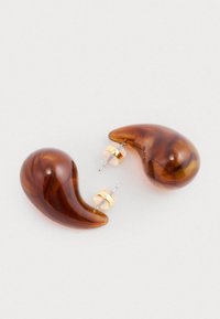 Brązowe kolczyki w kształcie kropli z gładkim, zakrzywionym kształtem. Złote metalowe akcenty w pobliżu sztyftu. Lekka konstrukcja odpowiednia do codziennego noszenia.