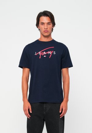Marineblå bomulds-t-shirt med korte ærmer, prydet med et hvidt og rødt grafisk logo foran. Lige snit og enkelt halsudskæring.
