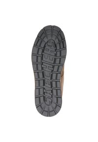 Suela de zapato Skechers que presenta un grueso y texturizado caucho negro con surcos profundos y una marca en relieve. Los bordes son marrones, lo que indica durabilidad.