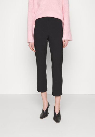 Black tailored cropped pants with a slim fit, featuring a smooth texture and no visible seams. Paired with a pink fuzzy sweater and black heels.