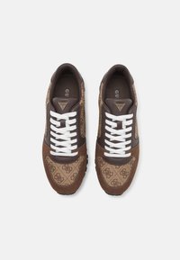 Braune Sneaker mit einem gemusterten Textil-Obermaterial, Suede-Akzenten, weißen Schnürsenkeln und einer kontrastierenden schwarzen Sohle. Logo auf der Zunge angebracht.
