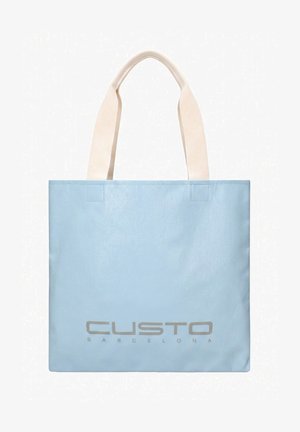Borsa tote rettangolare azzurro chiaro con manici in tessuto beige larghi e la scritta "CUSTO BARCELONA" stampata in grigio vicino al centro in basso.