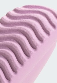 Ljubičasti anatomski jastučić od pjene sa konturama, s teksturiranom, valovitom površinom i glatkim rubovima, dizajniran za ergonomsko podržavanje i udobnost.