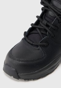Botas de caminhada pretas com uma combinação de couro texturizado e nylon durável. Biqueira reforçada e sistema de atilhos para um ajuste seguro.