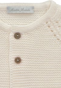 Cárdigan de punto color crema con un escote redondo, que presenta dos botones de madera y un delicado patrón de punto abierto cerca del cuello.