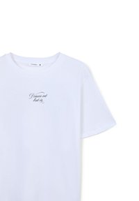 T-shirt bianca in cotone con scollo rotondo e maniche corte, caratterizzata da una piccola scritta nera sul davanti. Taglia S.