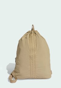 Mochila de nylon beige con cordón ajustable en la parte superior, detalles de costuras verticales y un bolsillo lateral con cremallera.