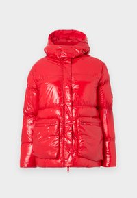 Veste matelassée rouge avec une finition brillante, un col montant, une fermeture éclair sur le devant, et deux poches avant ; présente une silhouette moderne et carrée.