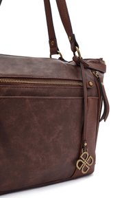 Bruine faux lederen handtas met een textuurfinish, voorzien van goudkleurige hardware, een voorzak met rits en een decoratieve logo charm.
