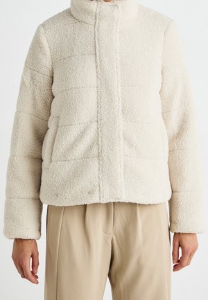 Giacca puffer in pile, di colore crema, con texture e colletto alto, caratterizzata da pannelli rettangolari. Presenta cuciture a linea e tasche frontali.