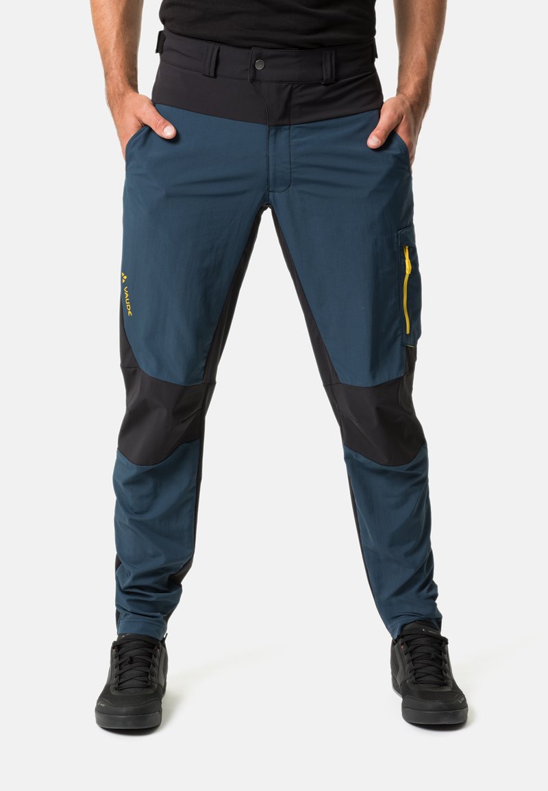 Pantalons d'extérieur bleus et noirs avec une poche latérale zippée et des accents jaunes. Fabriqués en matériau léger avec une coupe fuselée et des genoux renforcés.