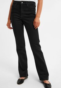 Svarta högmidjade jeans med rak benpassform. Tillverkade av denim, med framfickor, knäppning och en slät yta.