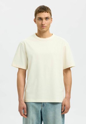 Kortærmet t-shirt med rund hals i blødt, off-white bomuldsstof. Har en afslappet pasform og et simpelt design uden synlige mønstre eller accenter.
