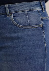 Jeans in denim blu scuro con una vestibilità classica, design a cinque tasche e cuciture visibili lungo le cuciture. Texture liscia con leggero elasticità.