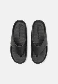 Mustat liukuesteet, joissa on teksturoitu pohja, sileät hihnat ja Nike-logo. Valmistettu joustavasta materiaalista, suunniteltu mukavuutta ja helppoutta varten.