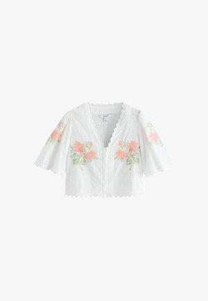 Weiße kurz geschnittene Bluse mit gewellten Kanten und Blumenstickerei in Pink und Grün auf Vorderseite und Ärmeln.