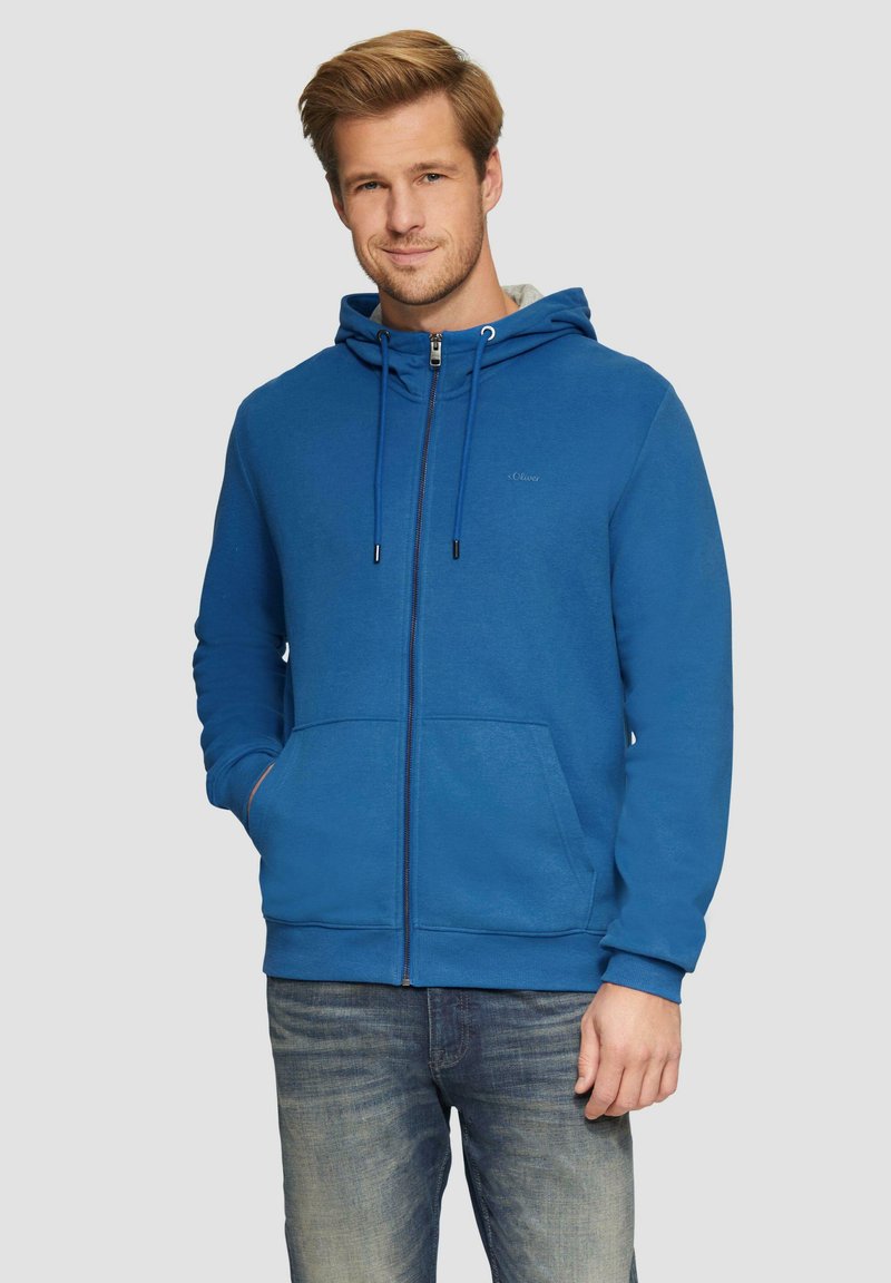 Blauwe zip-up hoodie van zachte stof, met een vo pocket, hood met trekkoord en geribde manchetten. Gemaakt om over denim jeans te dragen.