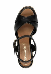 Sandalo in pelle nera con fasce incrociate, soletta imbottita e cinturino alla caviglia regolabile. Presenta una suola beige testurizzata con accenti neri.