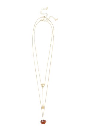 Zweischichtige Halskette aus Goldketten, kürzere Kette mit dekorativem runden Anhänger, längere Kette mit braunem ovalem Stein-Anhänger, der mit goldfarbenem Draht umwickelt ist.