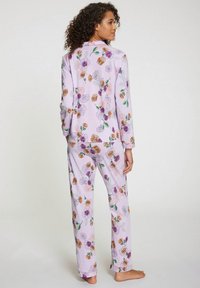 Pajama set s cvjetnim uzorkom u lavandi, izrađen od mekane tkanine; majica dugih rukava i odgovarajuće hlače s šarenim cvjetovima i zelenim lišćem.