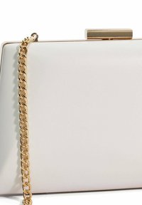 Witte leren clutch met een rechthoekige vorm, gouden kettingriem en een metalen sluiting aan de bovenkant. Glad textuur en minimalistisch ontwerp.