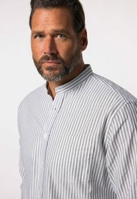 Camicia a maniche lunghe grigia e bianca a righe con colletto alla cinese e tasca sul petto, realizzata in un morbido tessuto misto cotone.