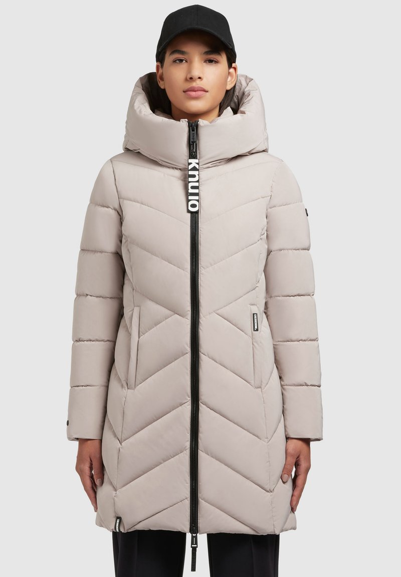 Gevoerde, lichtbeige parka met een capuchon, voorzien van een chevronpatroon, een volledige ritssluiting en een merkdetail op de ritssluiting.
